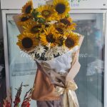 A close-up of a sunflower and a white chrysanthemum in a bright and cheerful bouquet